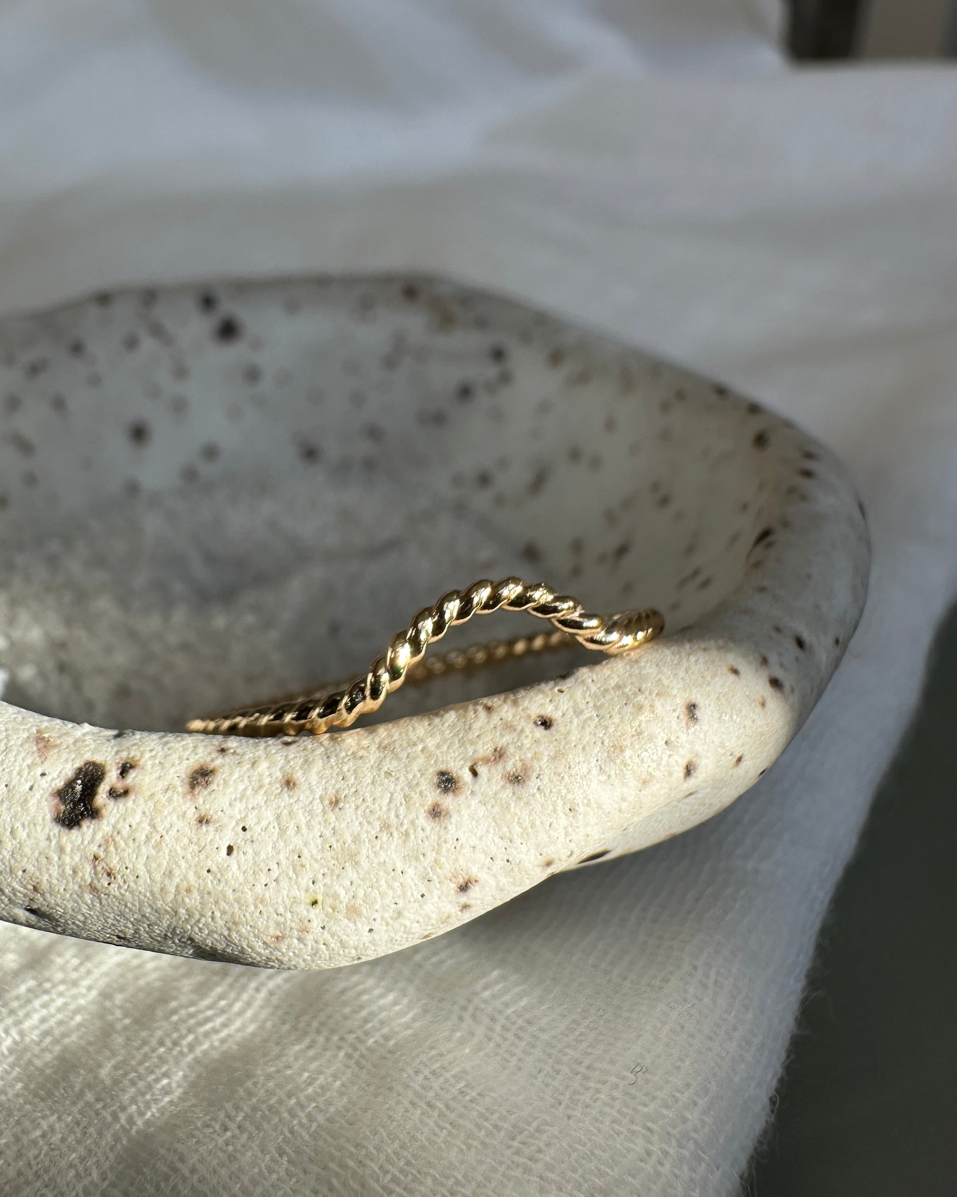 Gold twist ring on a white background