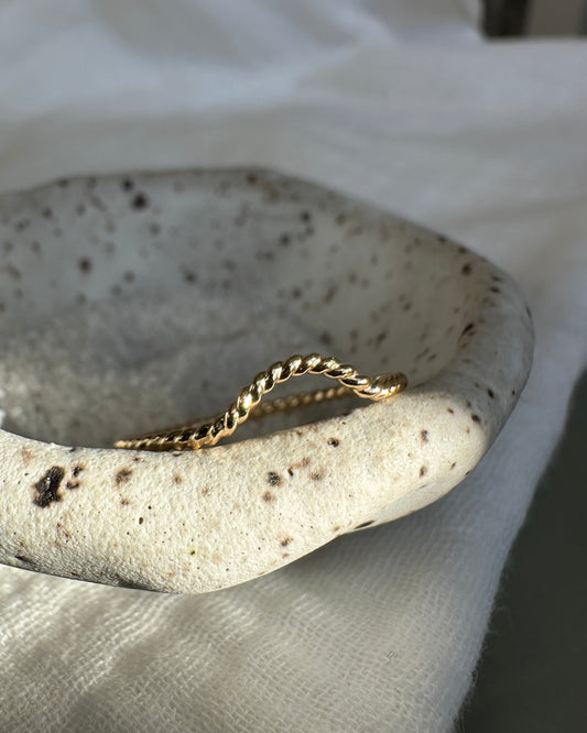 Gold twist ring on a white background
